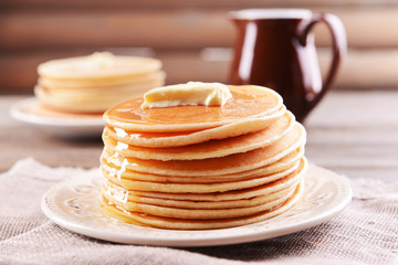 Delicious pancakes with honey on plate on table close-up