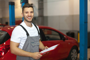 Smiling man in workwear holding a clipboard