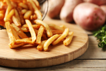 Tasty french fries in metal basket on wooden table background © Africa Studio