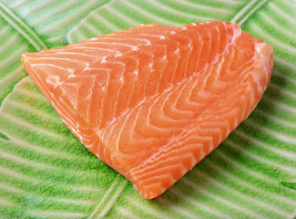 salmon steak red fish on banana leaf plate