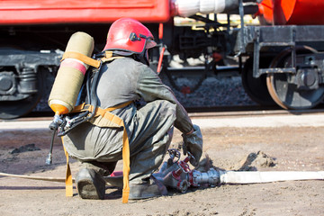 Fireman connecting firehose during fire fighting and rescue work