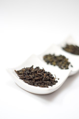 best quality oolong tea leaves on wite ceramic plate, on white background