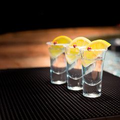 Three tequila shots with lemon