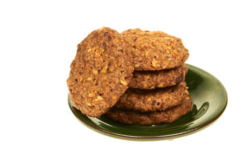 Biscuits with nuts isolated on a green plate on white background