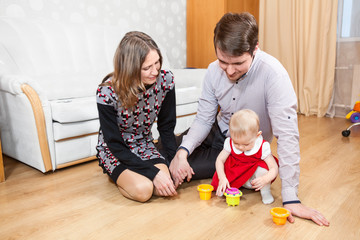 Fototapeta premium Three people Caucasian family playing on floor in room