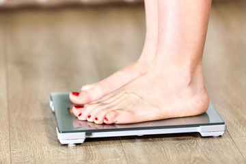 Close up of Caucasian woman with bare feet is on floor scales