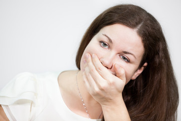 Caucasian young woman covering her mouth with hand