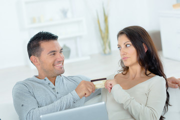 Playful couple arguing over on-line shopping