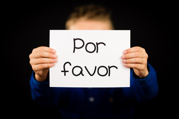 Child holding sign with Spanish words Por Favor - Please