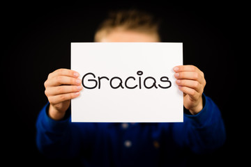 Child holding sign with Spanish word Gracias - Thank You