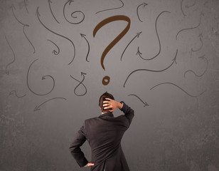 Business man looking at question mark sketch