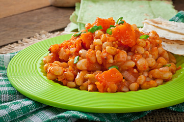 Stewed white beans and sliced pumpkin in tomato sauce