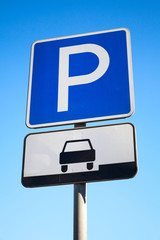 Blue parking road sign on blue sky background