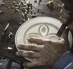 Hands of woodcarver make ​​wooden bowl