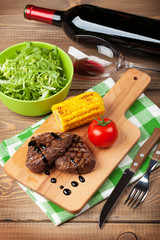 Steak with grilled corn, salad and red wine