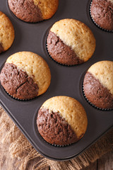 beautiful muffins in baking dish closeup, vertical top view