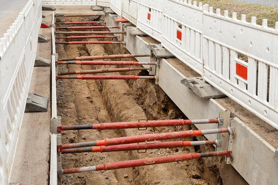 Verbauplatten und Absperrbaken sichern eine Baugrube