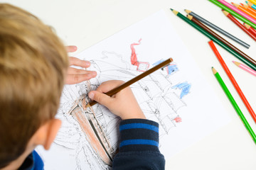 hands of young children drawing with multicolored pencils