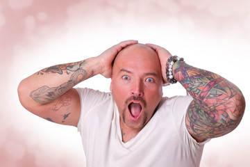 überraschter Mann mit Tattoos