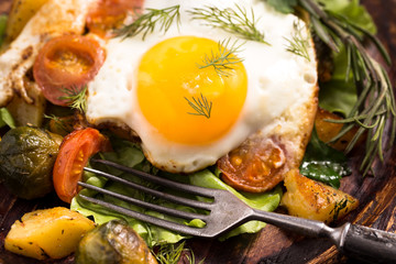 Fototapeta na wymiar Rustic fried egg and vegetables close-up
