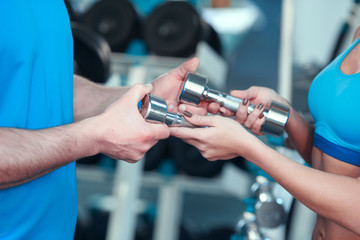 Beautiful girl in sports club with instructor