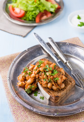 Stewed white beans in tomato sauce on toasted bread