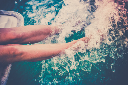 Fototapeta Female legs splashing sea water from a sailing yacht