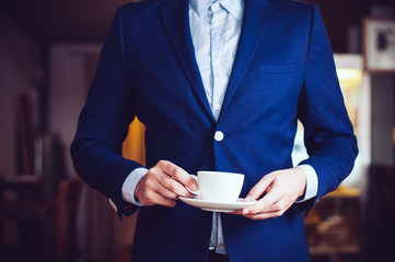 standing with a cup of coffee