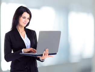 Businesswoman working at a laptop full length