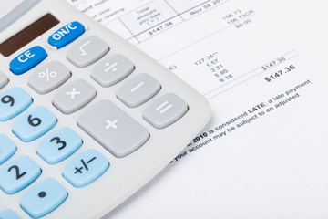 Calculator with utility bill under it - studio shot