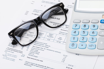 Calculator and glasses with utility bill under it - studio shot