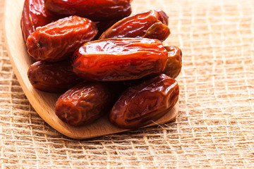 dried dates on wooden spoon cloth background