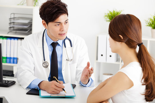 doctor talking with female patient in  office