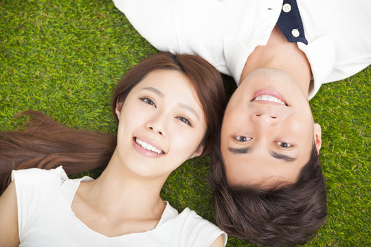 Top view of young couple  lying together on the grass