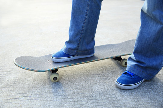 	skateboarder legs skateboarding at skatepark 