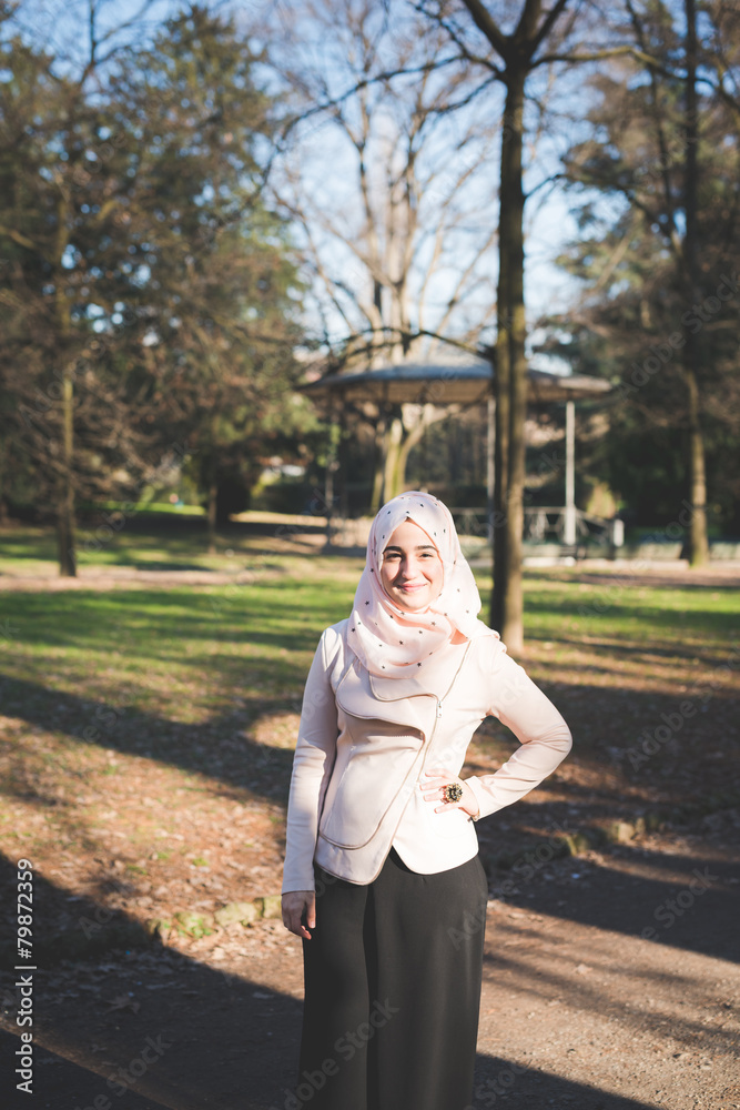 Wall mural young beautiful muslim woman at the park