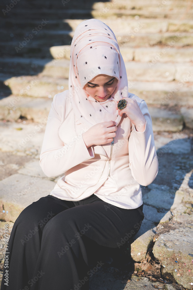 Wall mural young beautiful muslim woman at the park