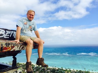 Hiker sits on a pillbox on the Lanikai Bunkers hike, Oahu