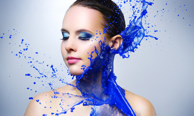Beautiful girl and blue paint splashes
