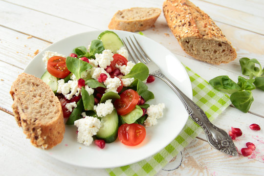 Healthy salad with lettuce, white cheese and pomegranate fruit