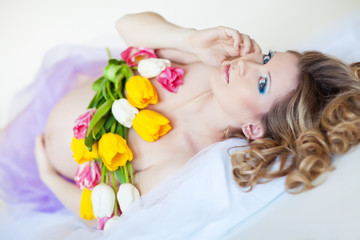 Obraz na płótnie Canvas Happy pregnant woman with bouquet tulips