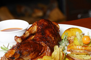 The baked half of duck with a potato, apples and pineapple