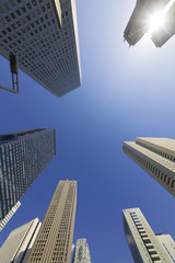 Fototapeta na wymiar 快晴　青空　超広角で見上げる新宿高層ビル群 東京都庁のツインタワーから差す太陽