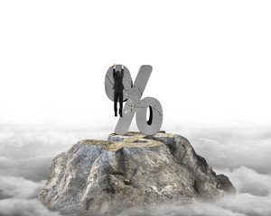 Businessman hanging on cracked percentage sign with dollar peak