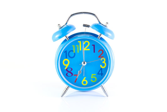 Alarm Clock isolated on white, in blue, showing seven o'clock.