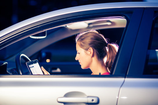 Pretty, Female Driver Using Her Tablet Computer