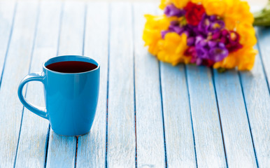 Cup of coffee and bouquet of flowers