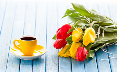 Cup of coffee and bouquet of tulips