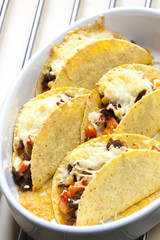 baked tacos filled with minced beef meat, beans and tomatoes