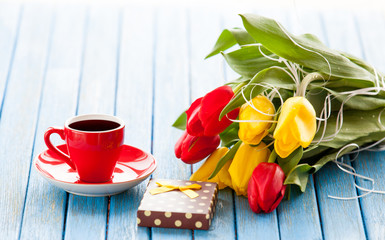 Fototapeta na wymiar Cup and gift box with bouquet of tulips